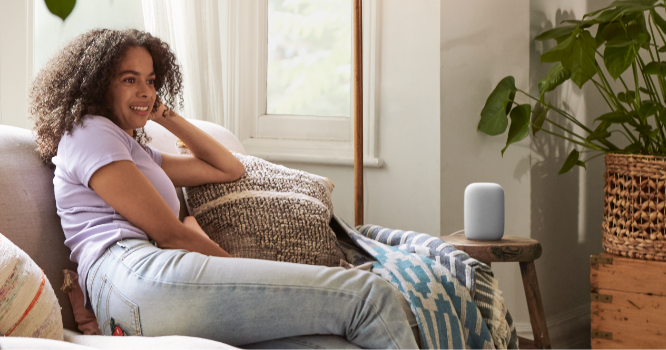 Nest Audio speaker on side table assisting woman with commands