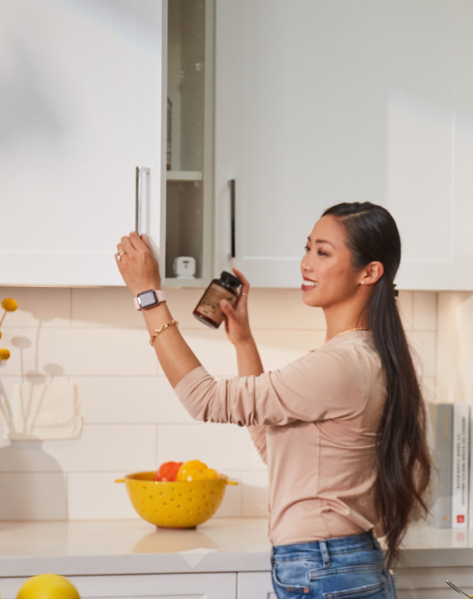 Woman retrieving medicine from cabinet