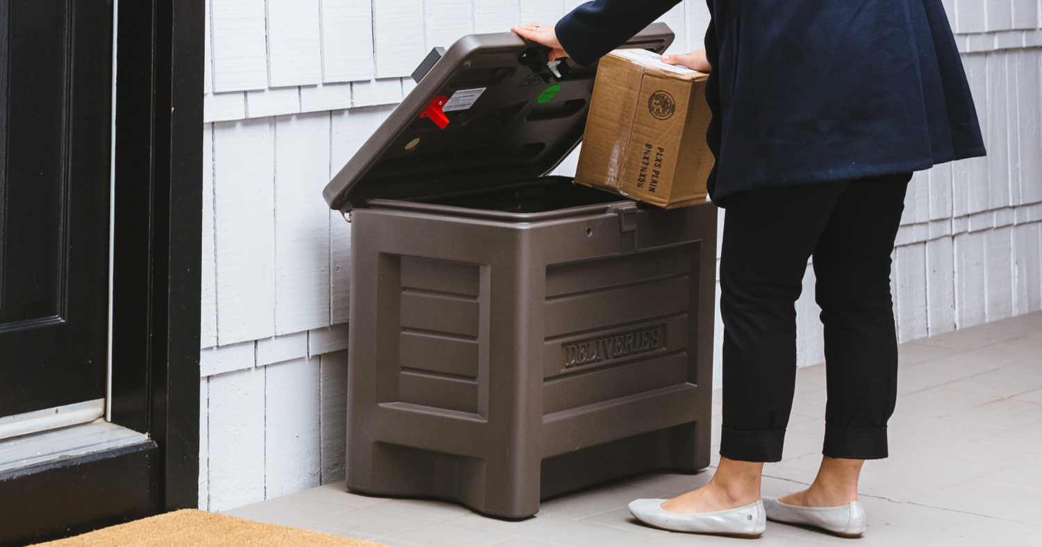 woman taking package box out of Yale Smart Delivery Box after a secure home package delivery