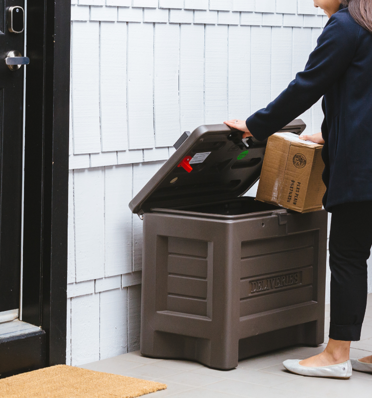 woman taking package box out of Yale Smart Delivery Box after a secure home package delivery