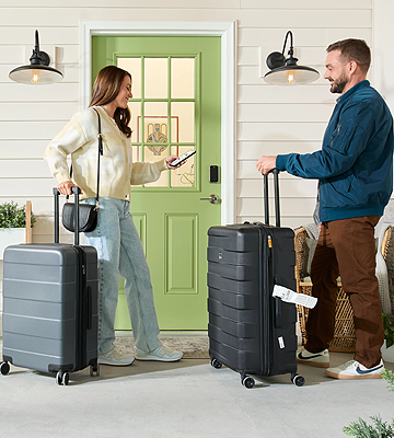 Man and woman standing on front porch by smart lock with suitcases and a smart phone