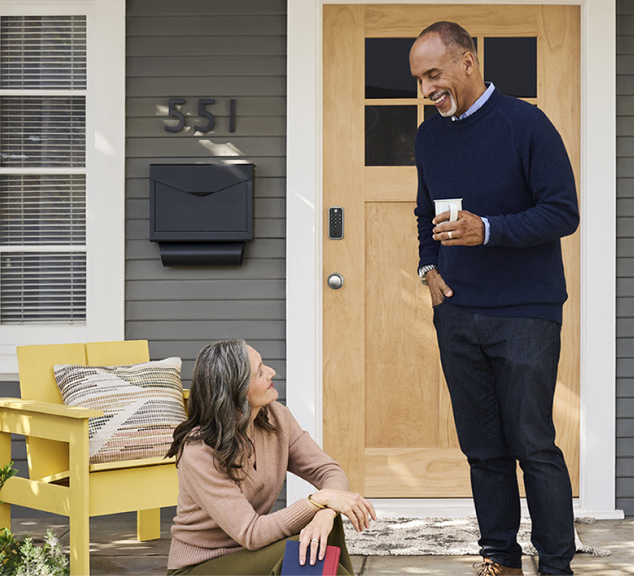 people talking out front of a house installed with a yale code keypad lock