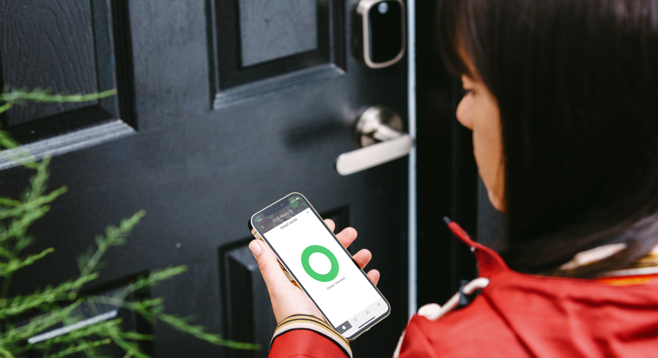 Woman using smart phone to unlock front door for smart lock home entry.